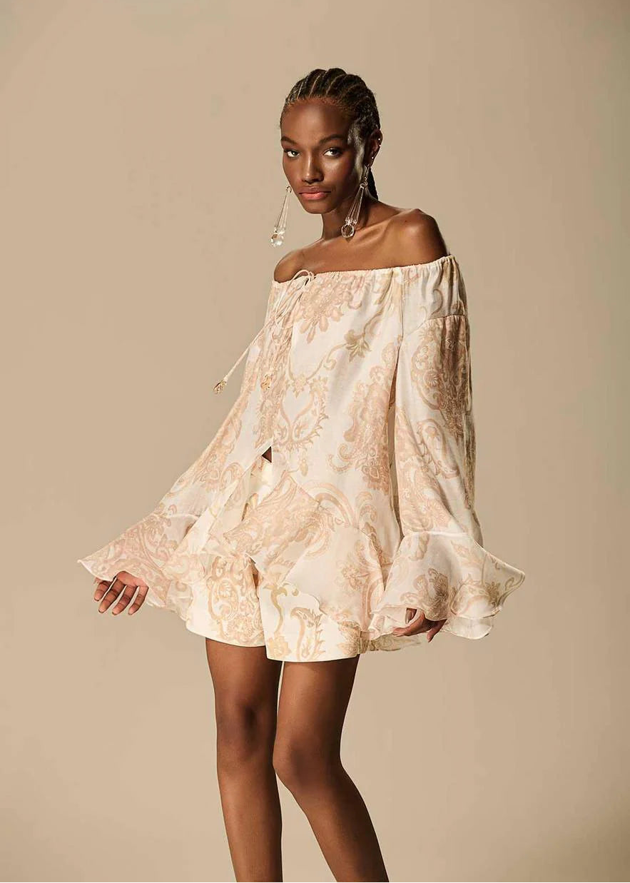 Woman wearing a floral off-shoulder dress against a beige background