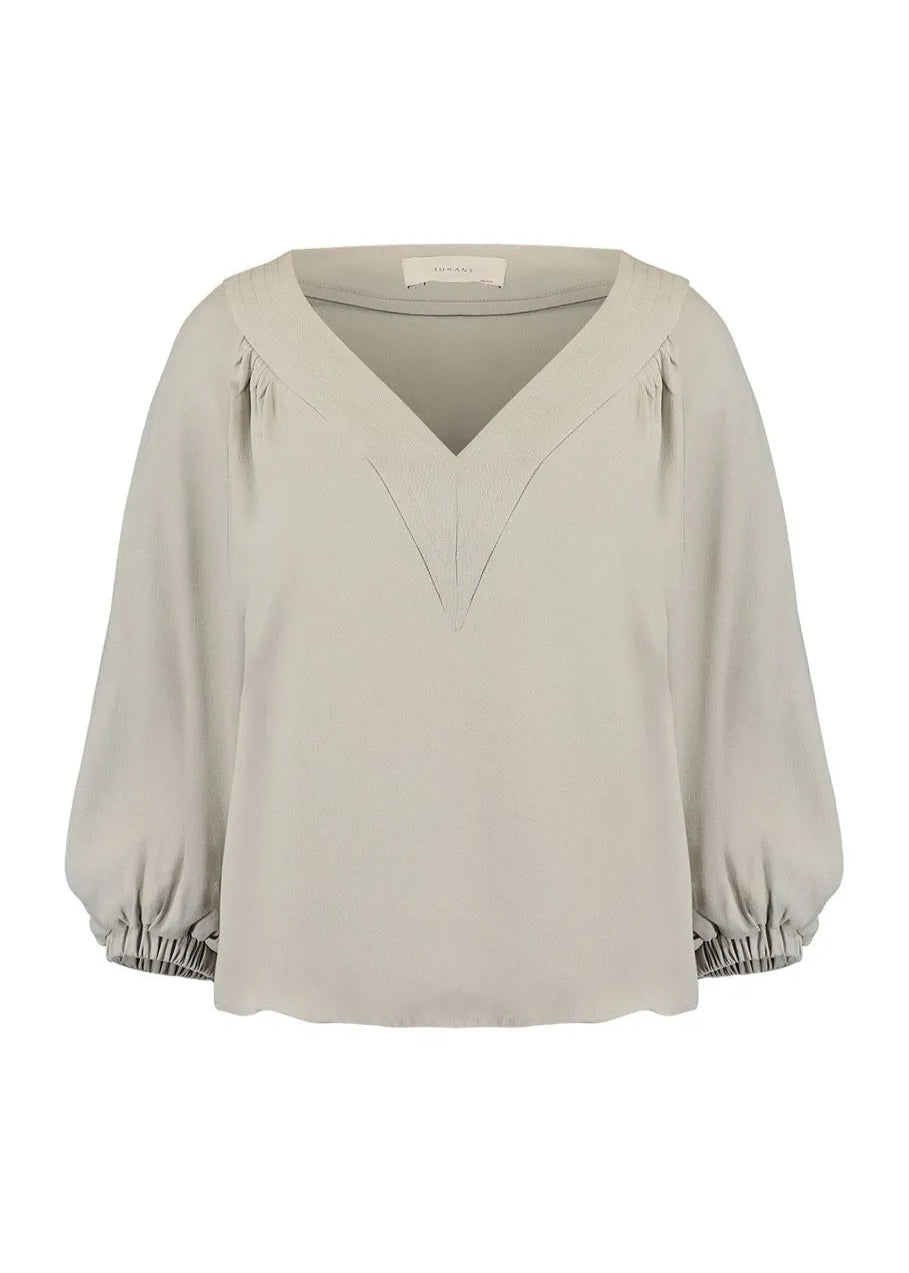 Beige blouse with balloon sleeves on a white background
