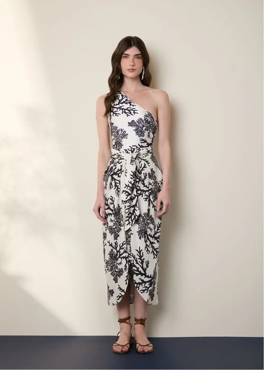 Woman wearing a black and white floral dress against a plain background