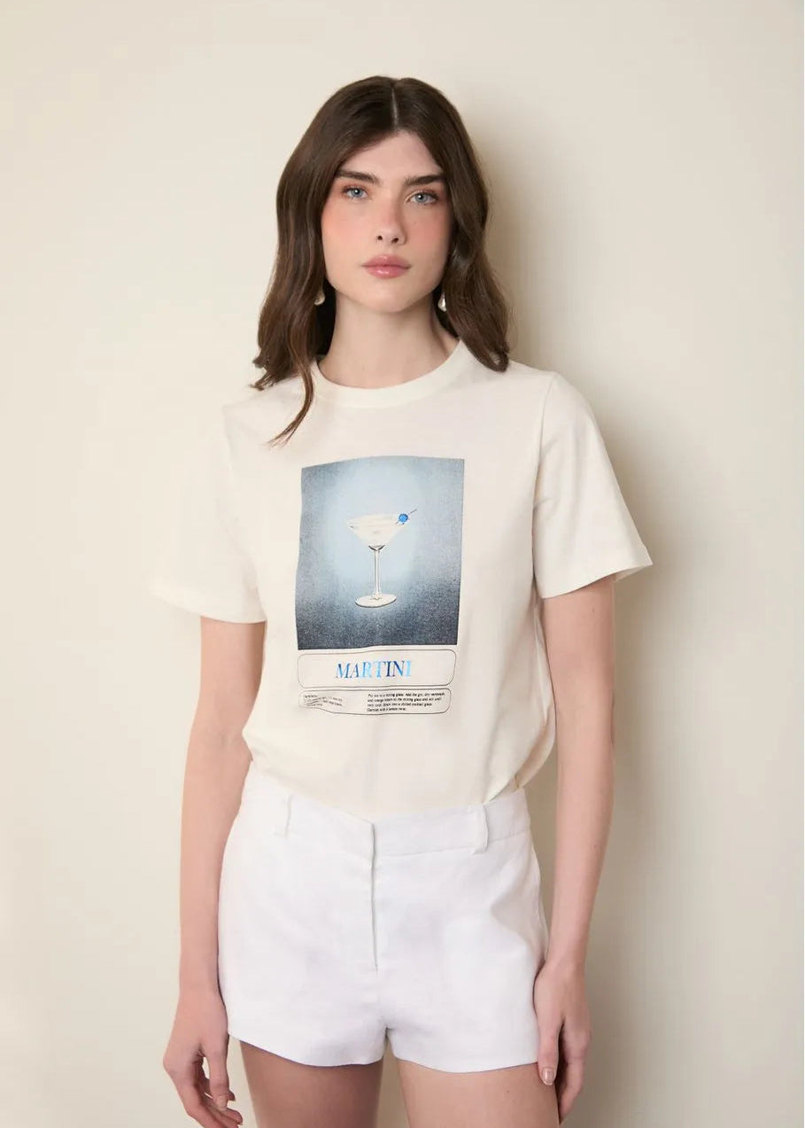 Woman wearing a white t-shirt with a graphic design against a plain background