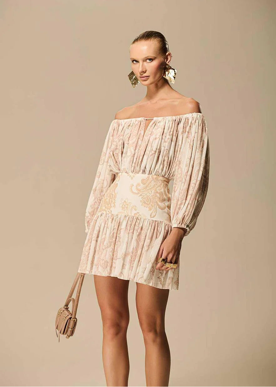 Woman wearing a beige off-shoulder dress against a beige background