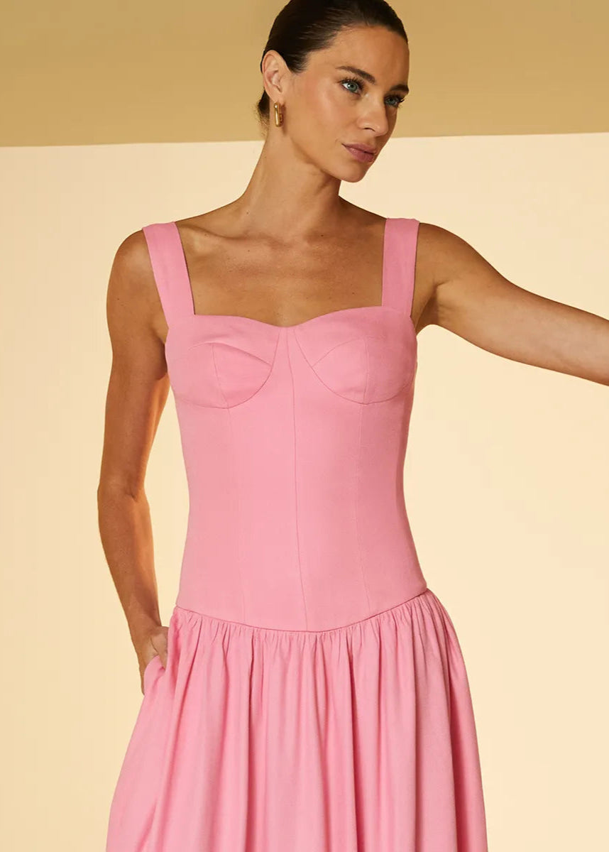 Woman wearing a pink dress against a beige background