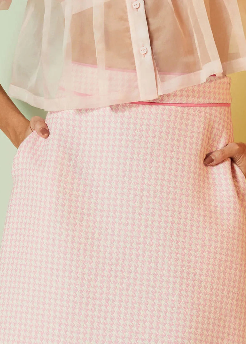 Person wearing a pink checkered skirt with a blurred background