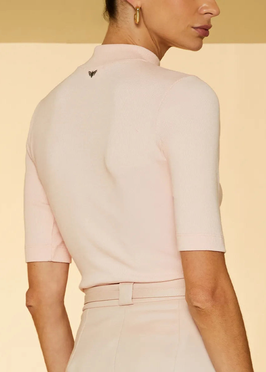 Woman wearing a light pink outfit with a subtle design on a beige background