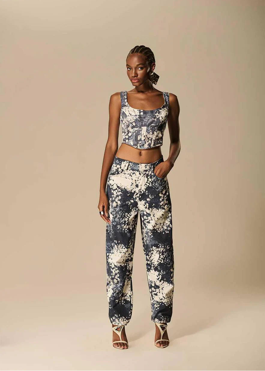 Woman wearing a floral top and pants on a beige background