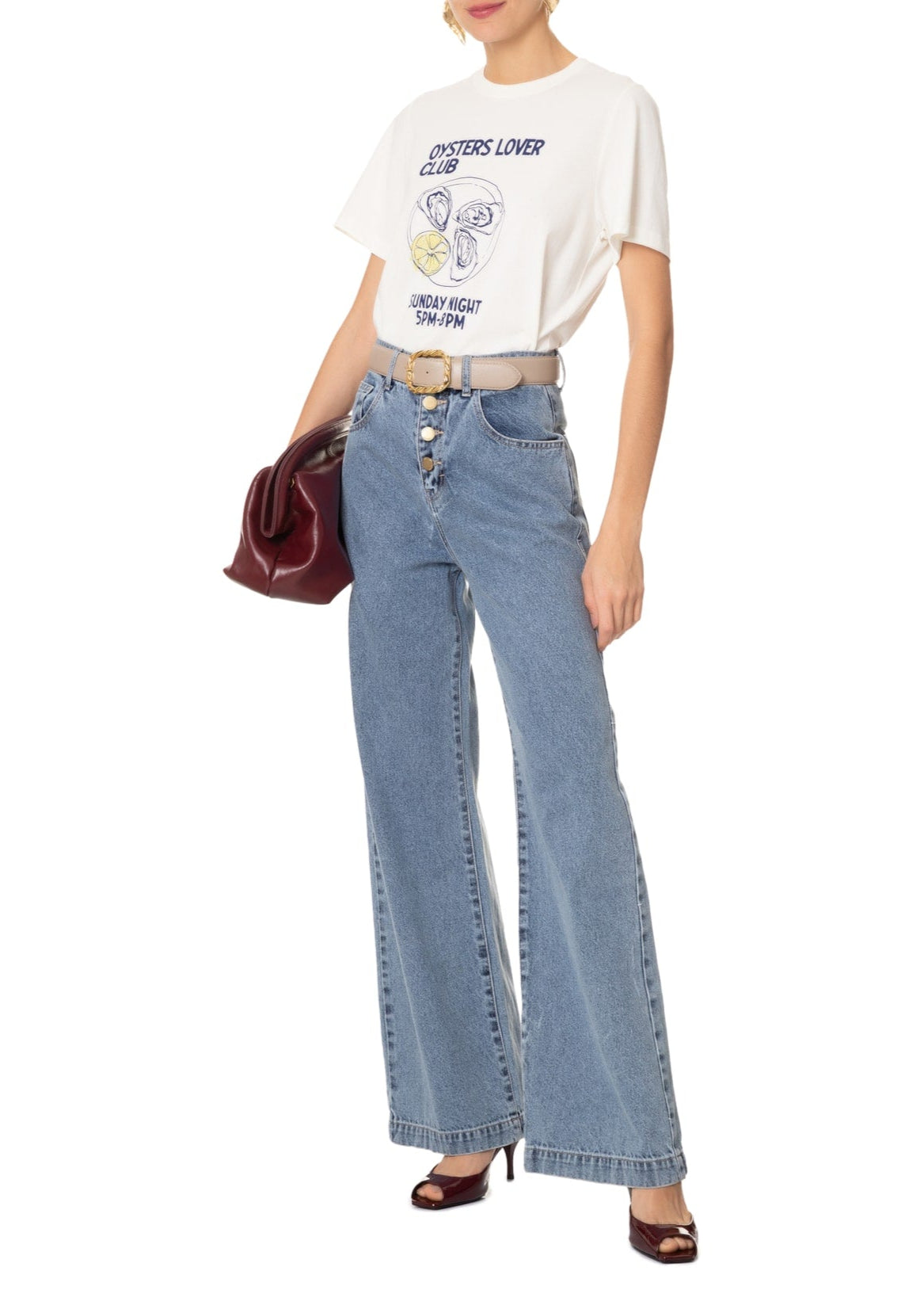 Person wearing a graphic t-shirt and blue jeans with a white background