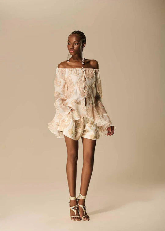 Woman wearing a floral off-shoulder dress against a beige background