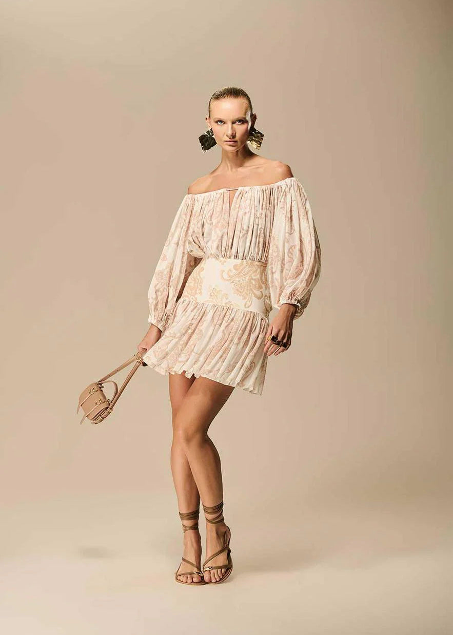 Woman wearing a floral off-shoulder dress against a beige background