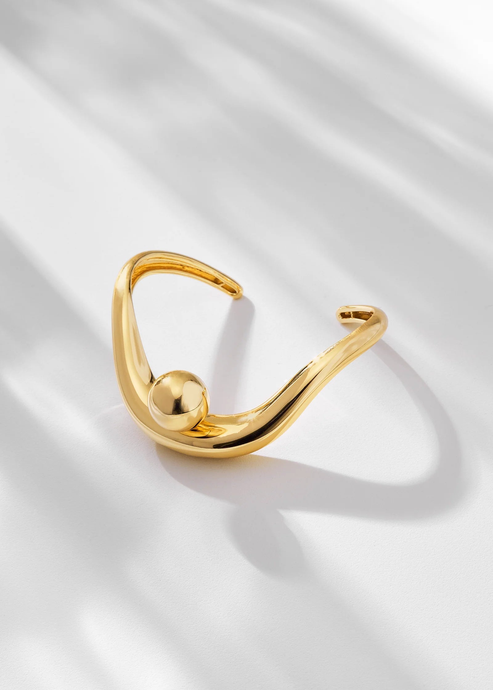 Gold ring with a unique design on a light fabric background