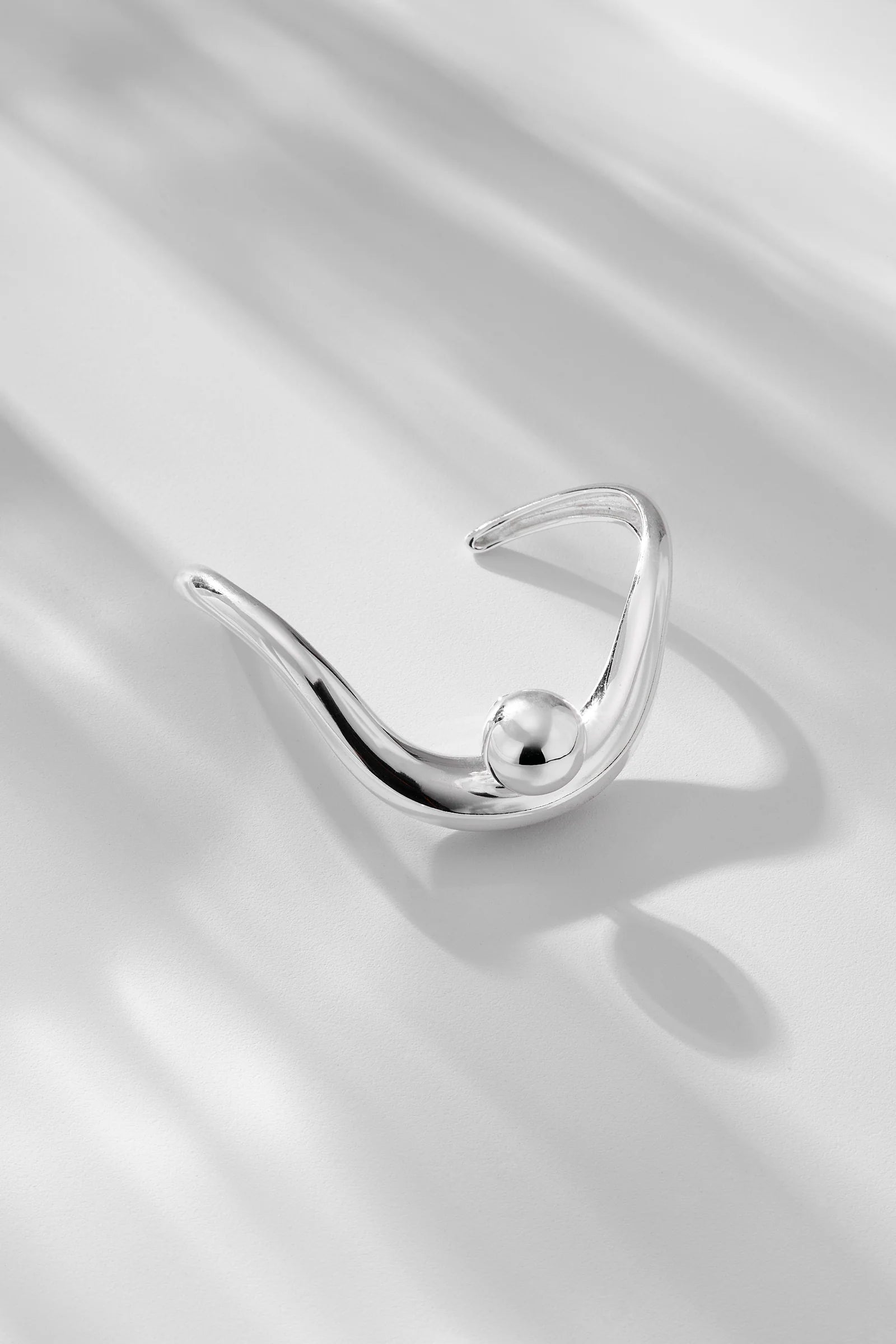 Silver ring with a pearl on a satin surface