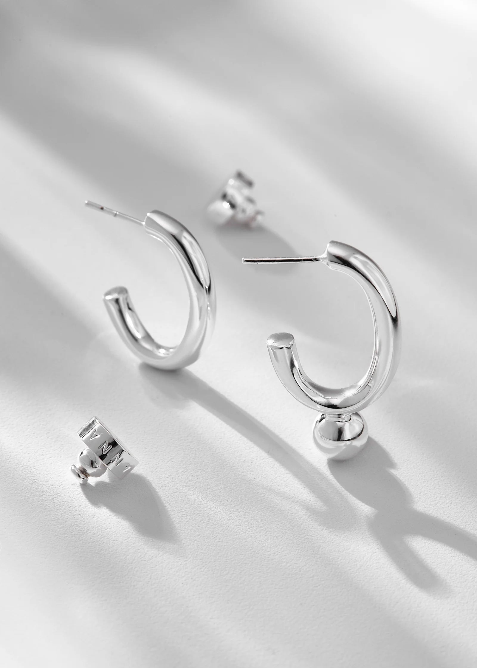 Silver hoop earrings on a light gray background