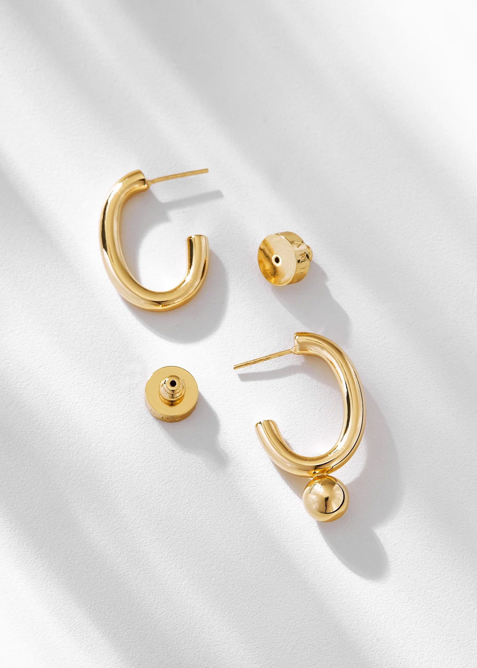 Set of gold hoop earrings on a light background