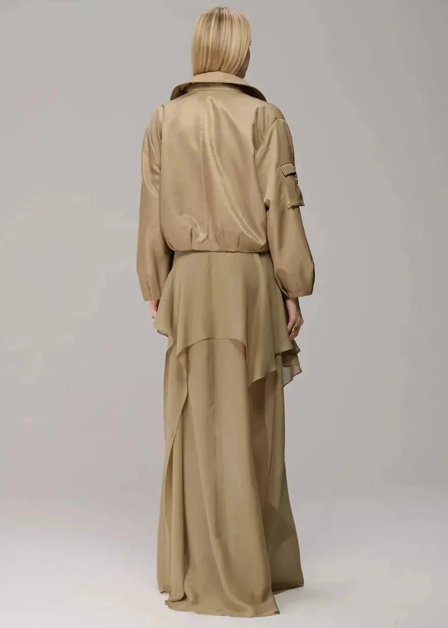 Person wearing a beige coat and skirt set on a plain background
