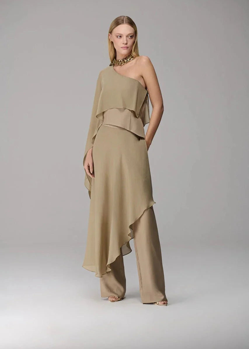 Woman wearing a beige one-shoulder dress on a gray background