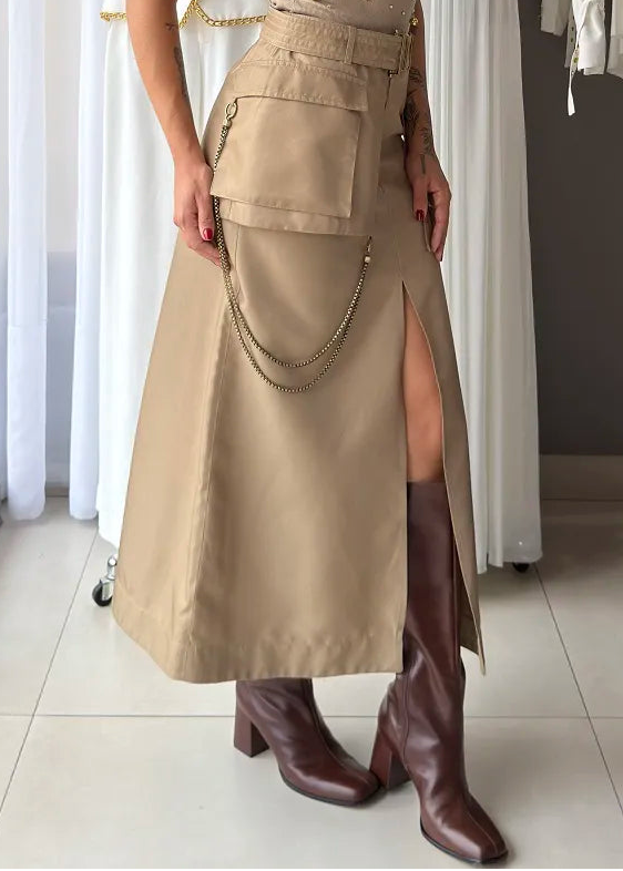 Woman wearing a skirt dress with a slit and brown boots in a clothing store.