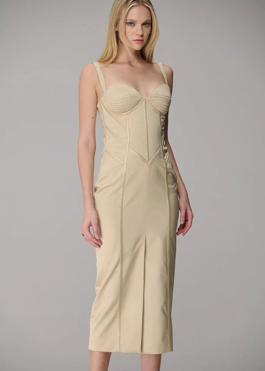 Woman wearing a beige dress against a gray background