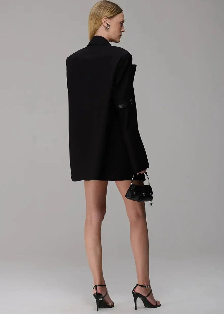 Woman wearing a black blazer and skirt set with high heels on a plain background