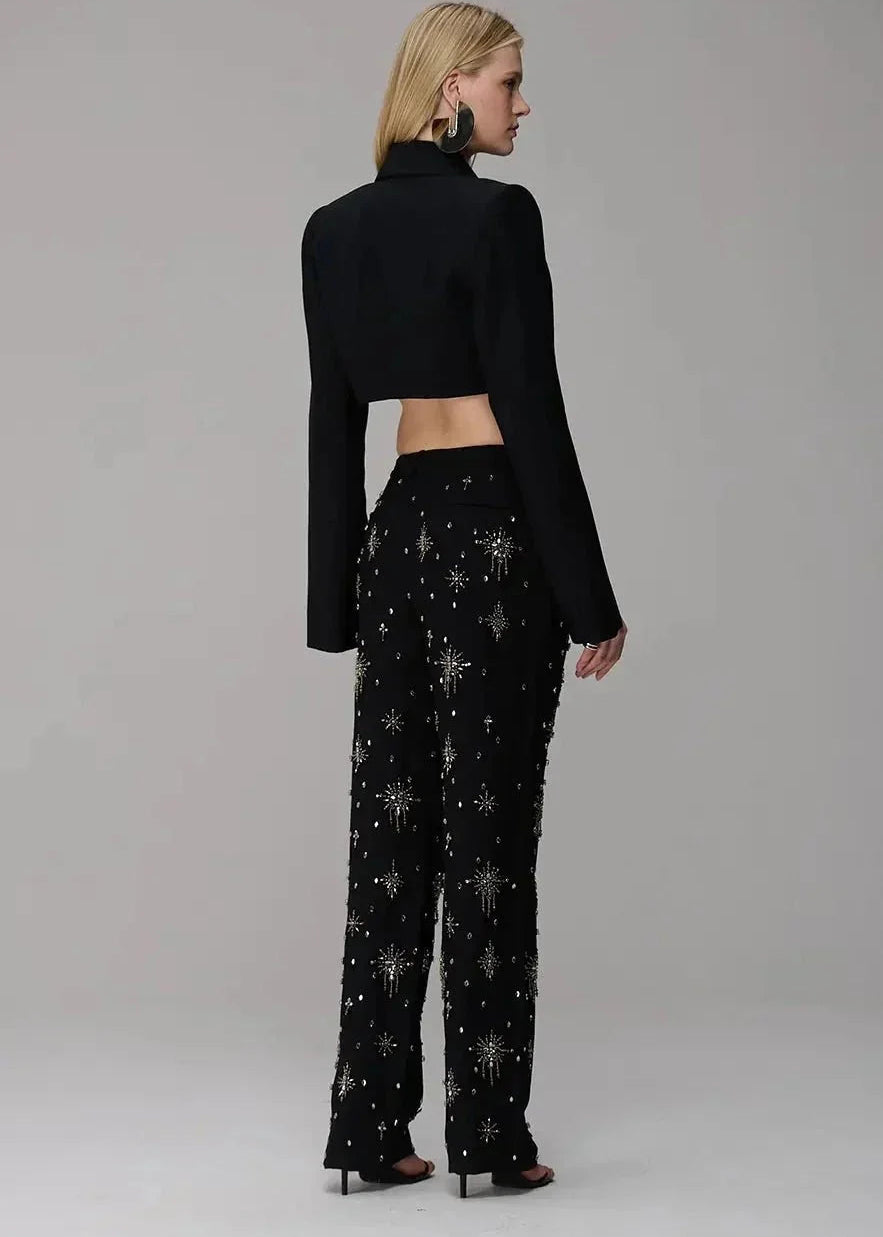 Woman wearing a black outfit with star patterns on a plain background