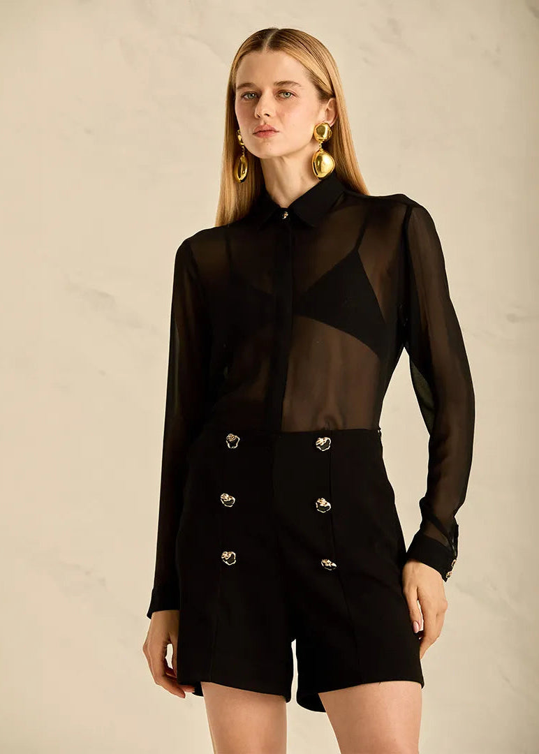 Woman wearing a black tailored with golden button