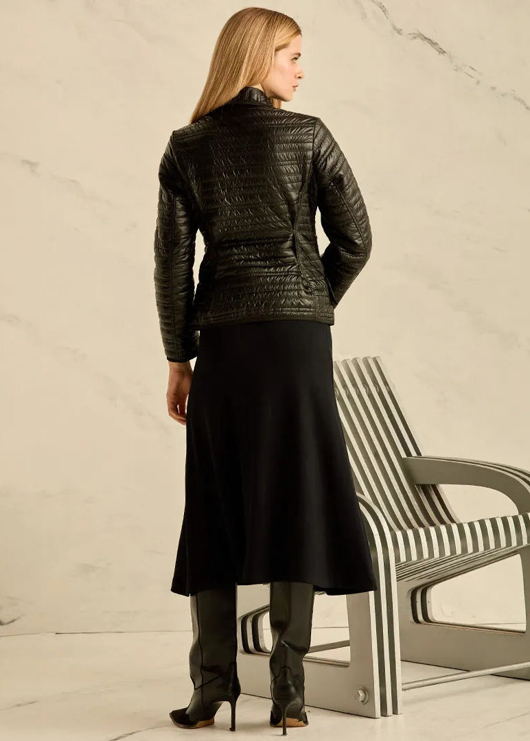 Woman wearing a black leather jacket and a black skirt