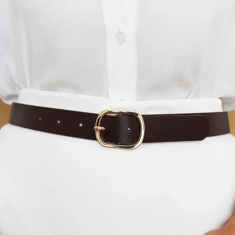 Brown belt with a gold buckle worn by a person in a white shirt.