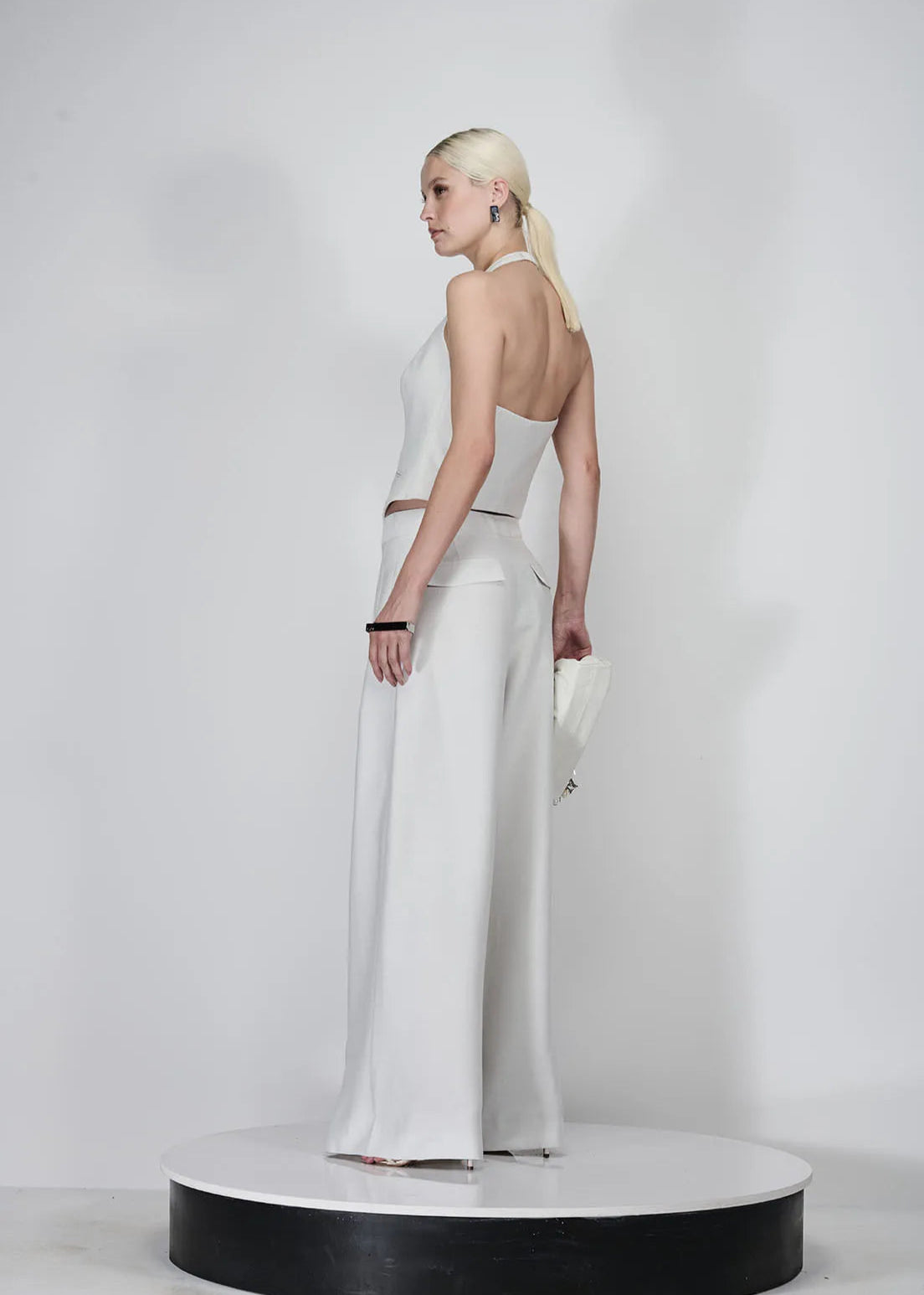 Woman wearing a white dress with a high slit on a white background