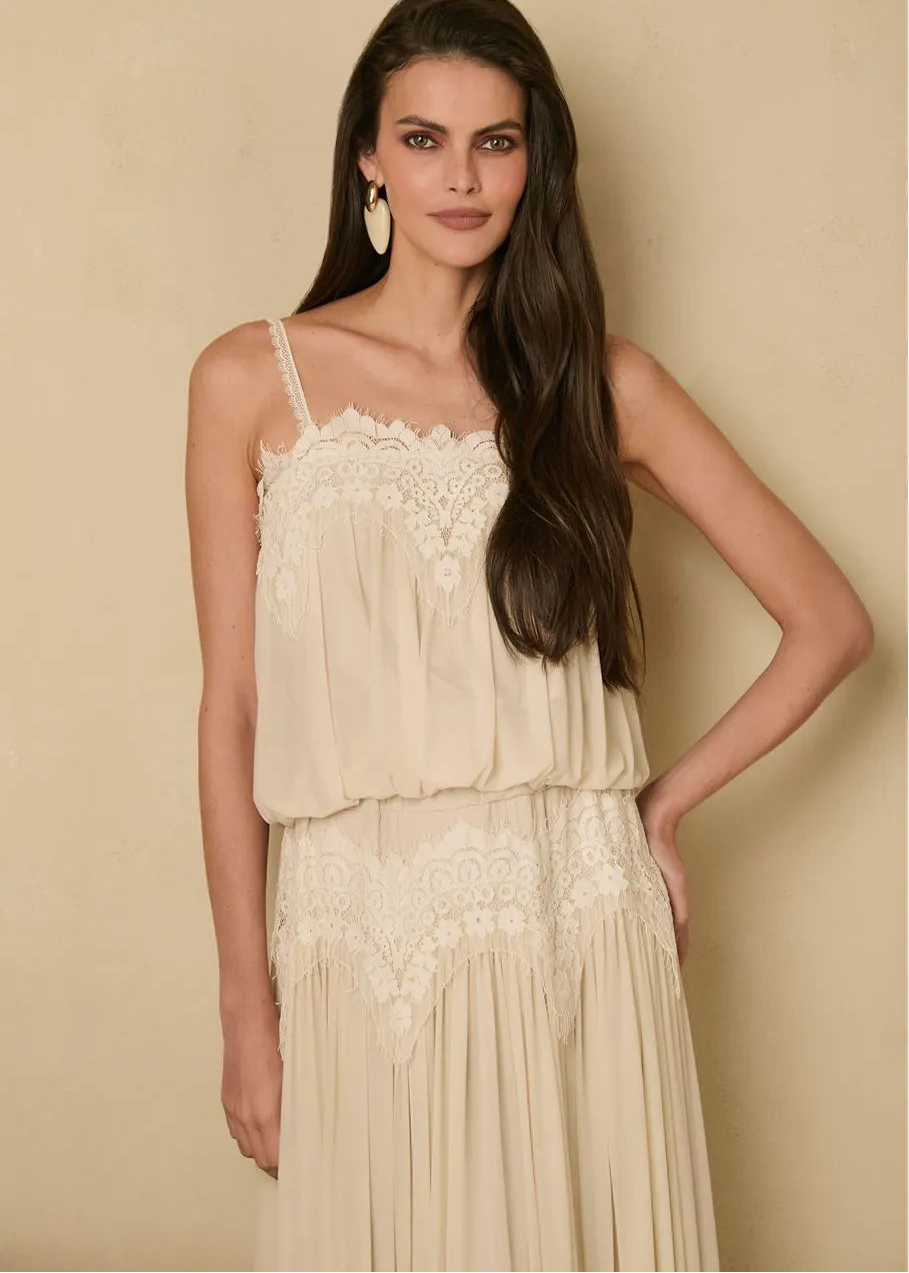 Woman wearing a beige lace dress against a beige background