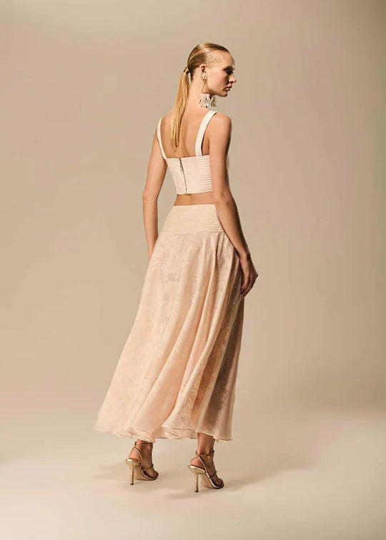 Woman wearing a beige dress with a plain background