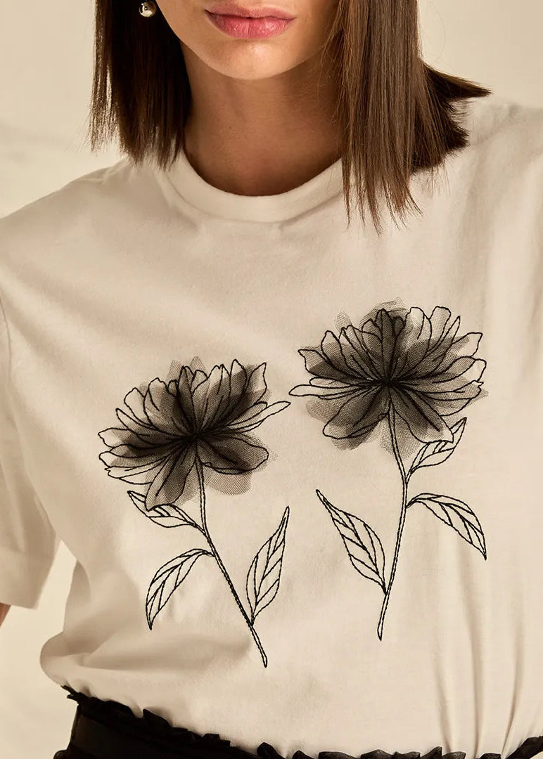 Woman wearing a white t-shirt with black floral designs