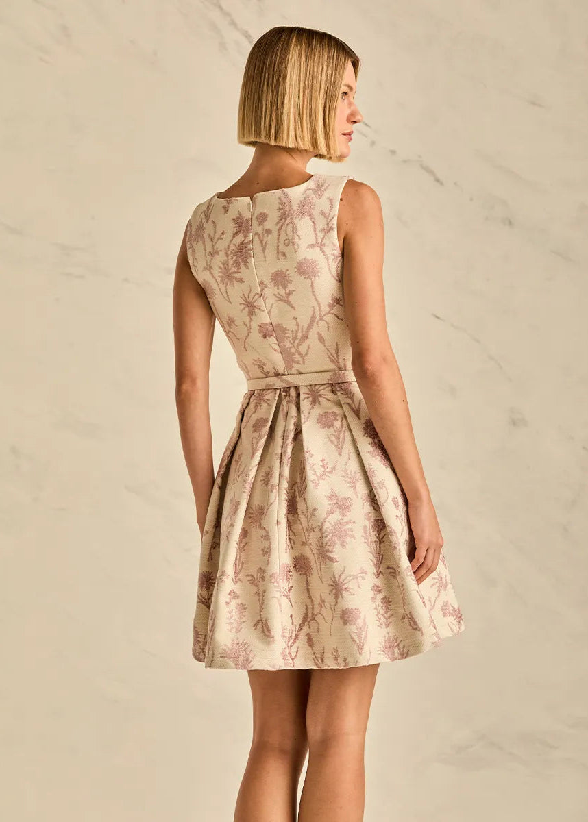 Woman wearing a floral dress against a neutral background