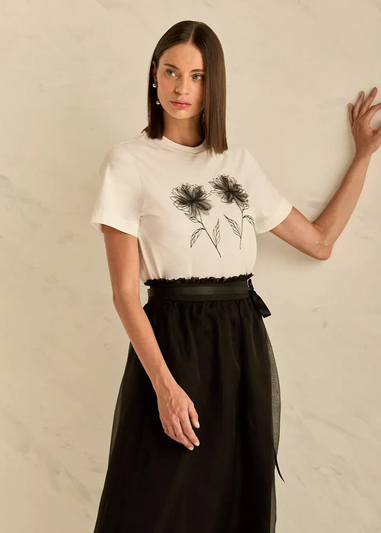 Woman wearing a white t-shirt with black floral design