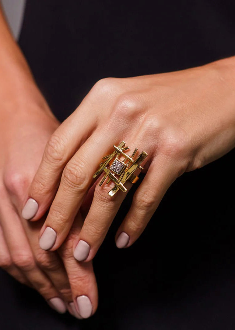 Close-up of hands with a gold ring on a dark background