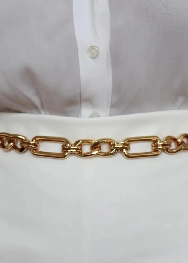 Gold chain belt worn with a white shirt and pants