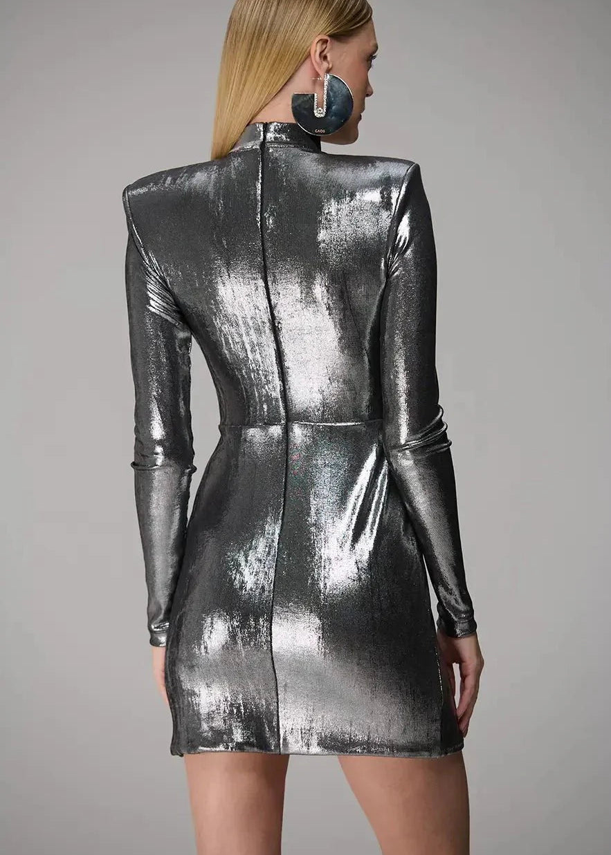 Person wearing a metallic silver dress against a gray background