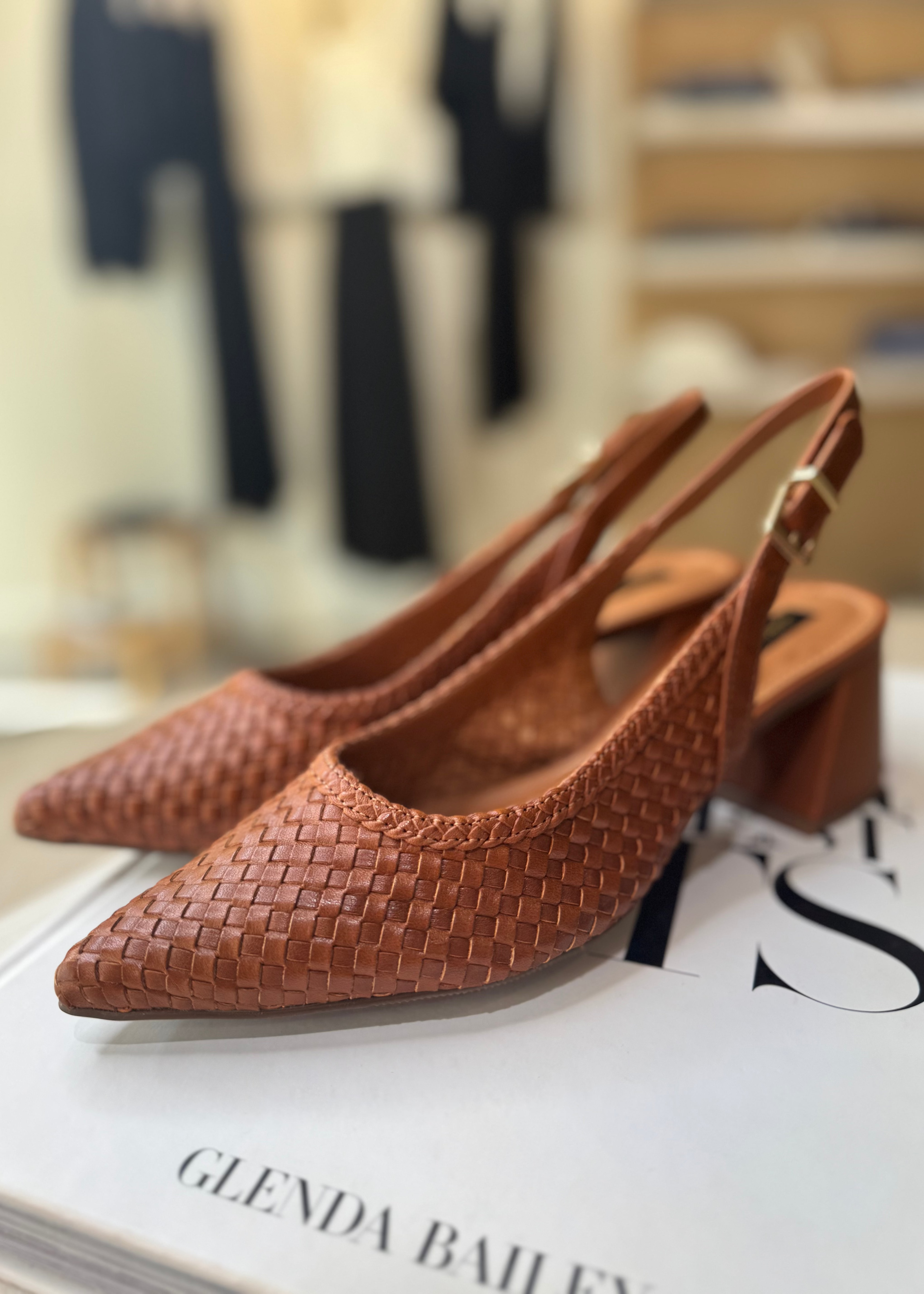 Brown woven slingback shoes on a magazine with blurred background