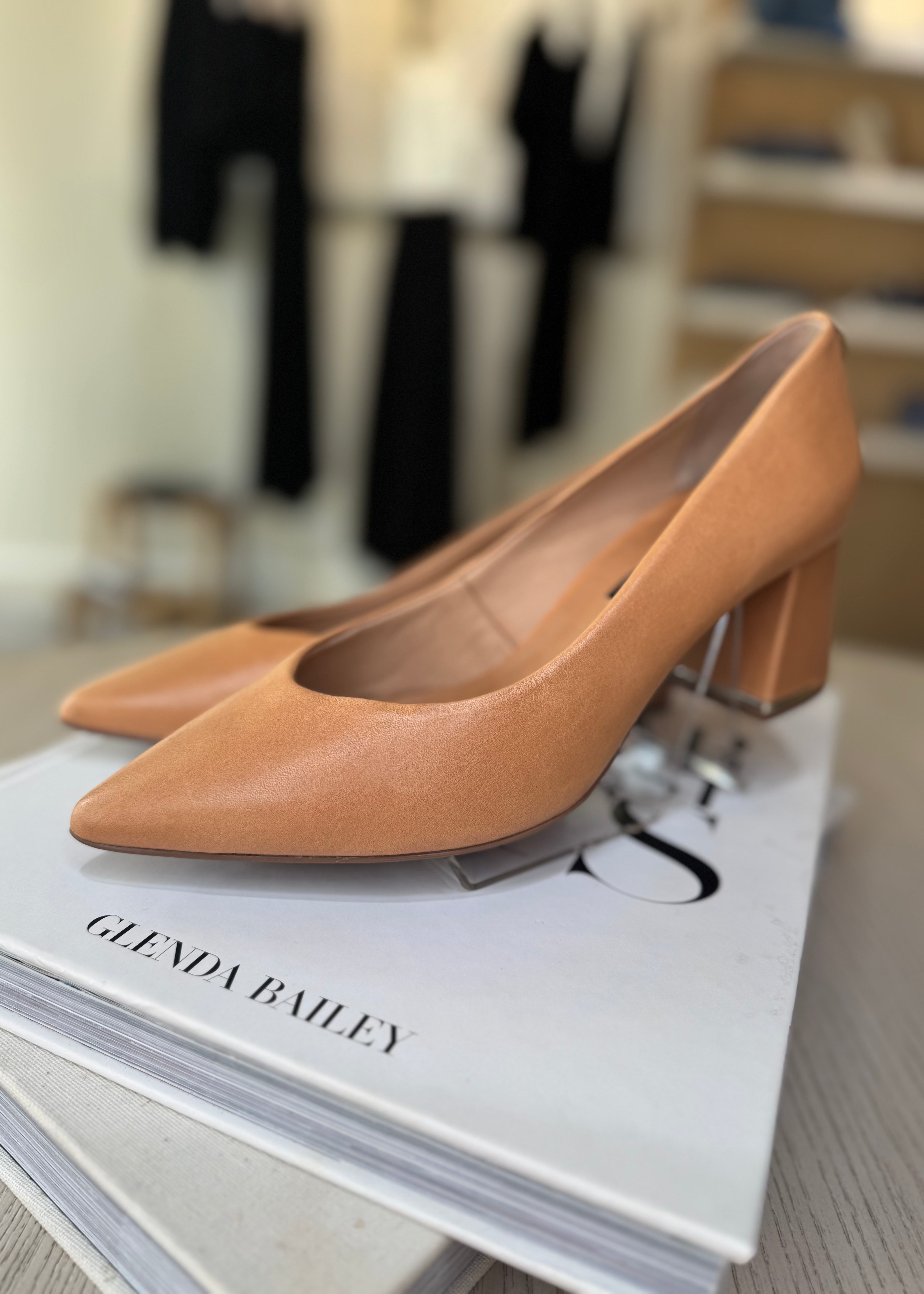 Tan high-heeled shoes on a magazine with a blurred background