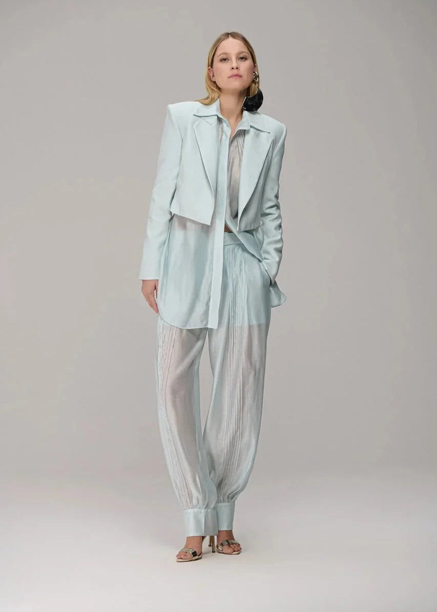 Woman wearing a light blue outfit on a plain background