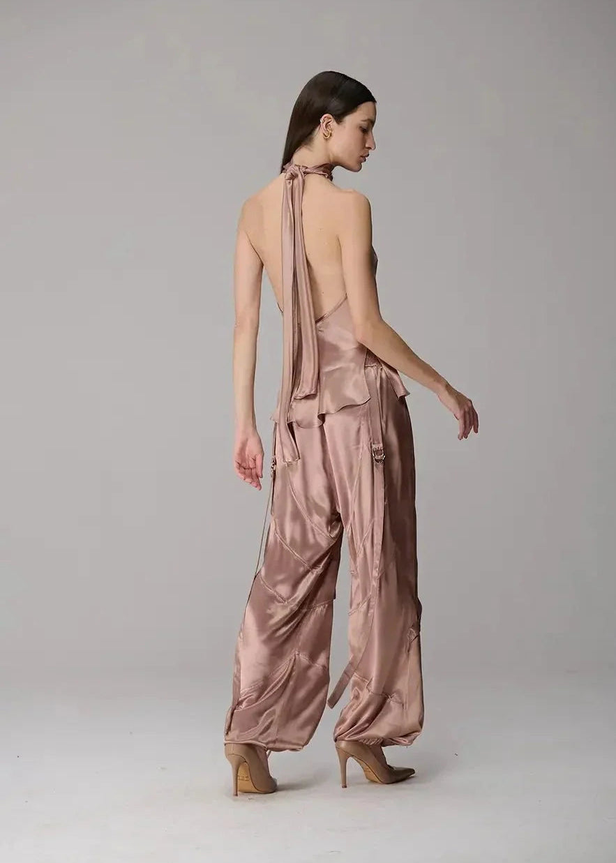 Woman wearing a pink satin outfit on a plain background