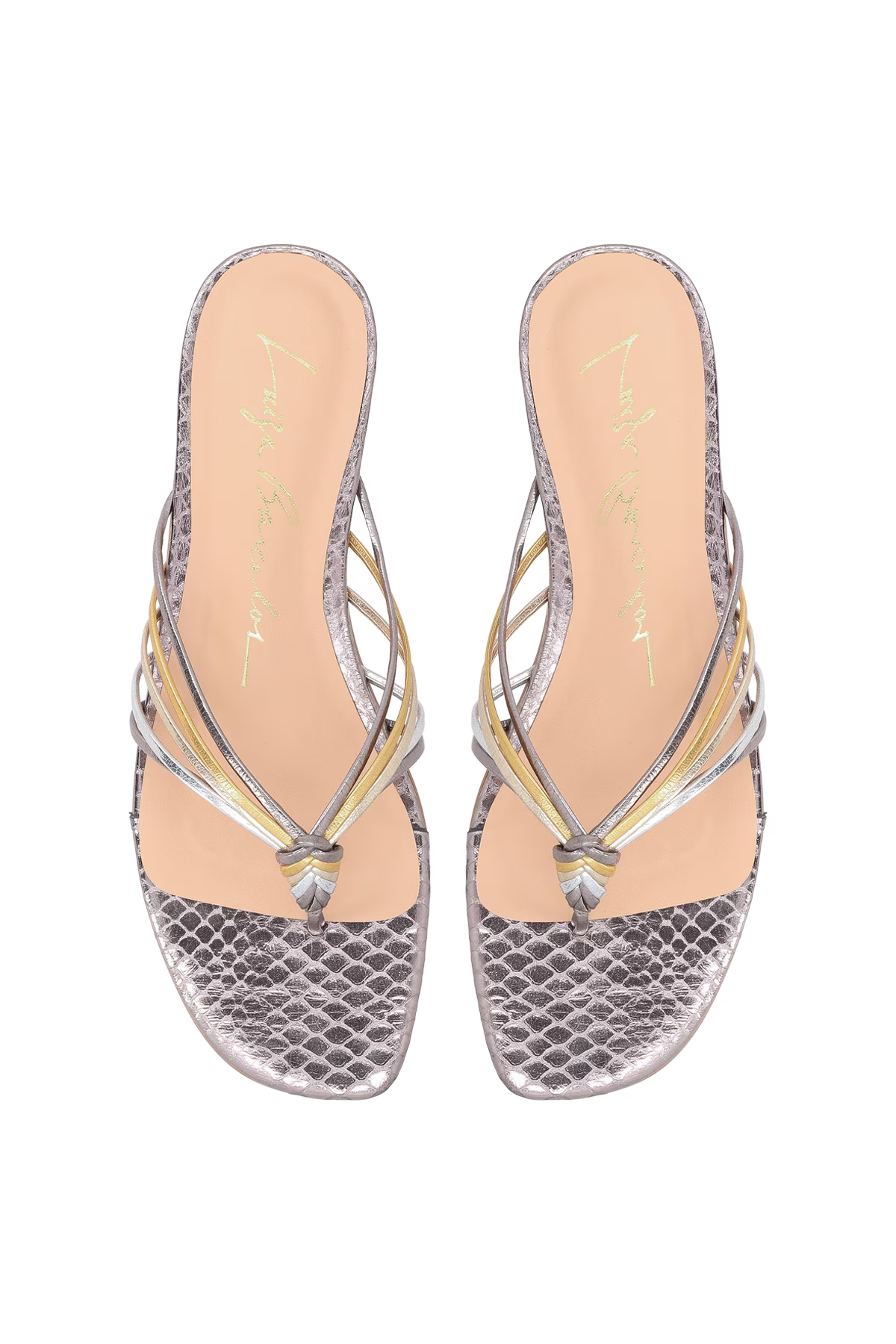Pair of silver sandals with snake print soles on a white background