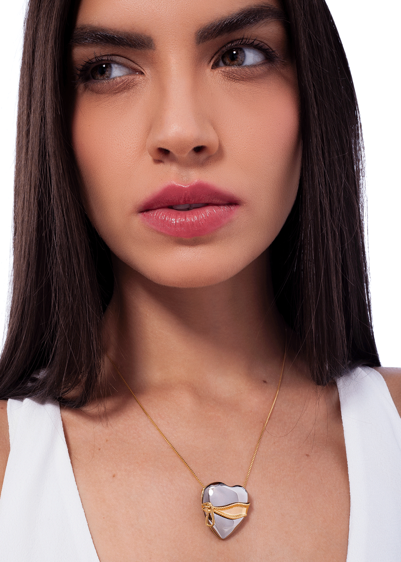 Woman wearing a gold necklace with a heart-shaped pendant on a white background