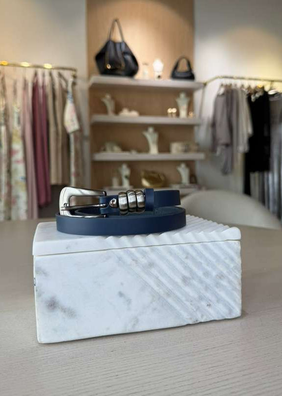 Blue belt on a white textured box with a clothing store background