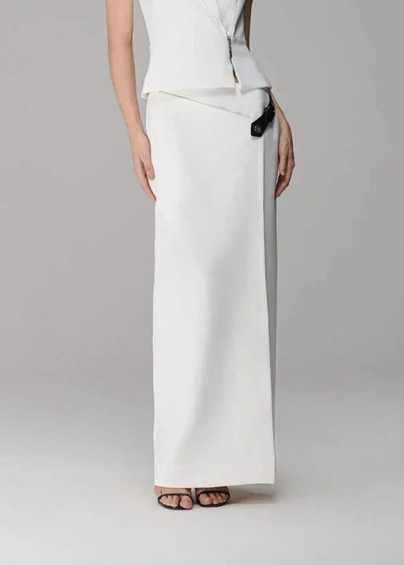 Woman wearing a white sleeveless top and wide-leg pants on a gray background