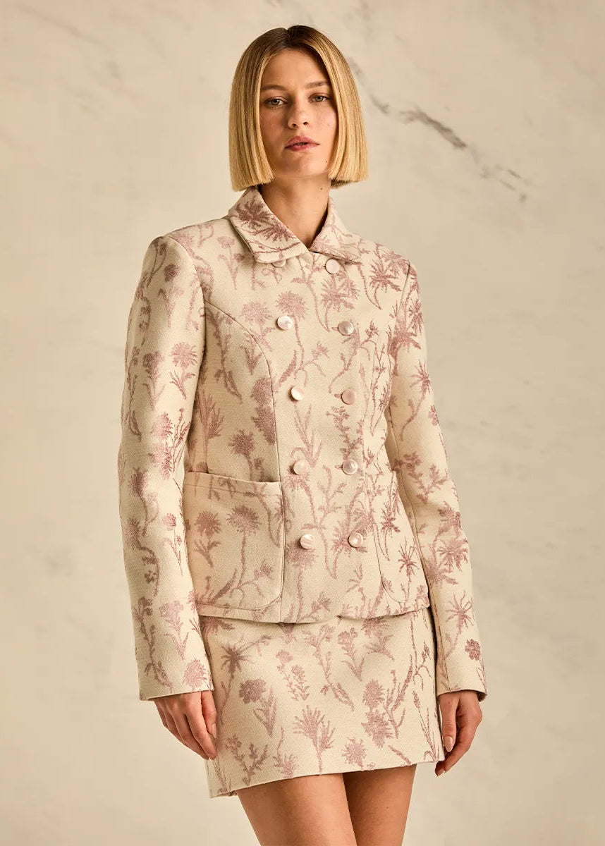 Woman wearing a floral two-piece suit against a neutral background