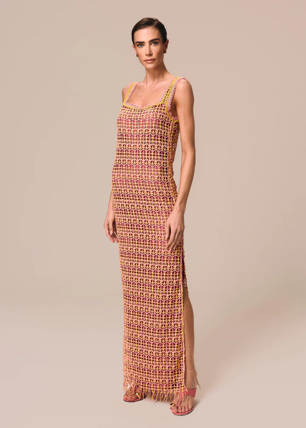 Woman wearing a long, patterned dress against a plain background