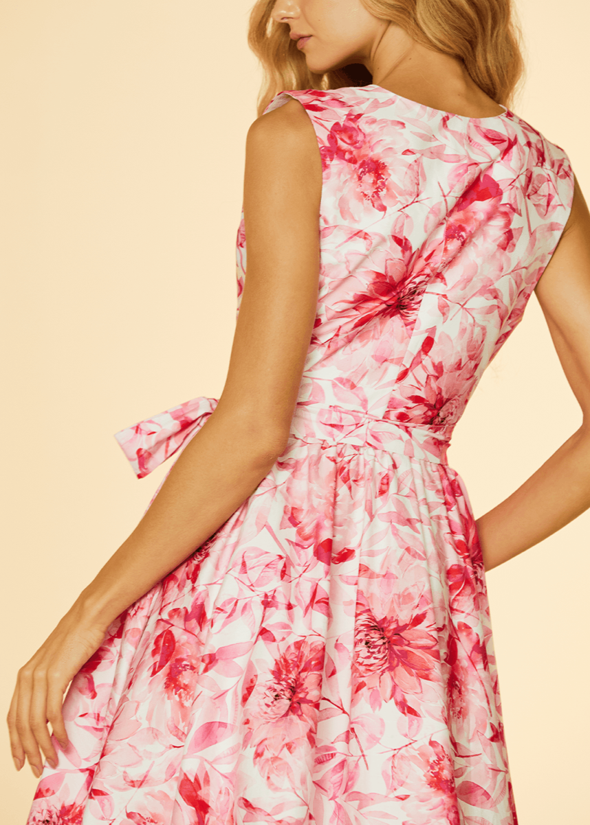 Woman wearing a pink floral dress on a beige background