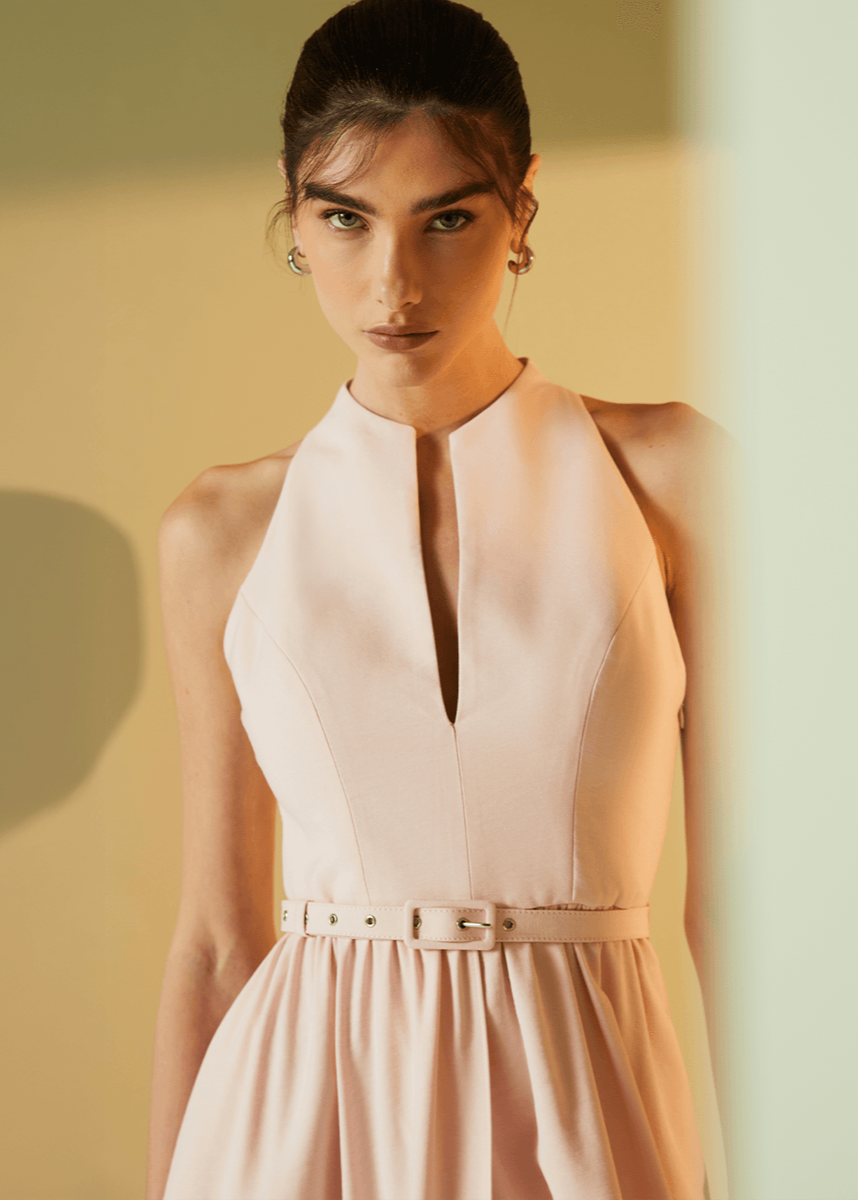 Woman wearing a light pink dress against a neutral background