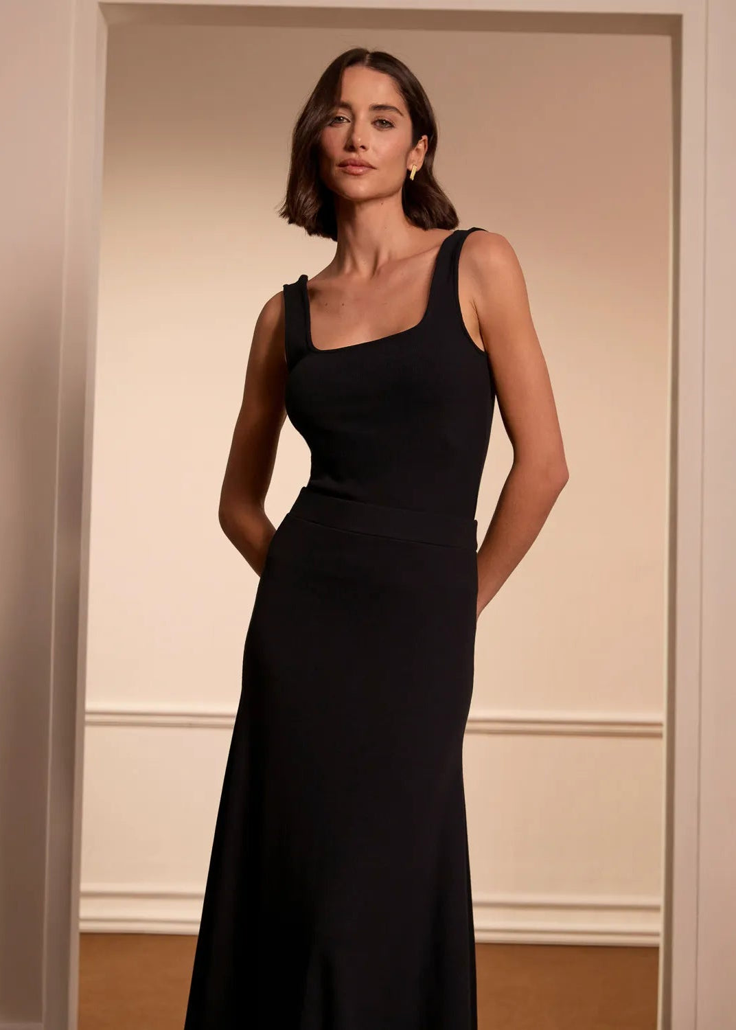 Woman wearing a black dress set of tank top and skirt