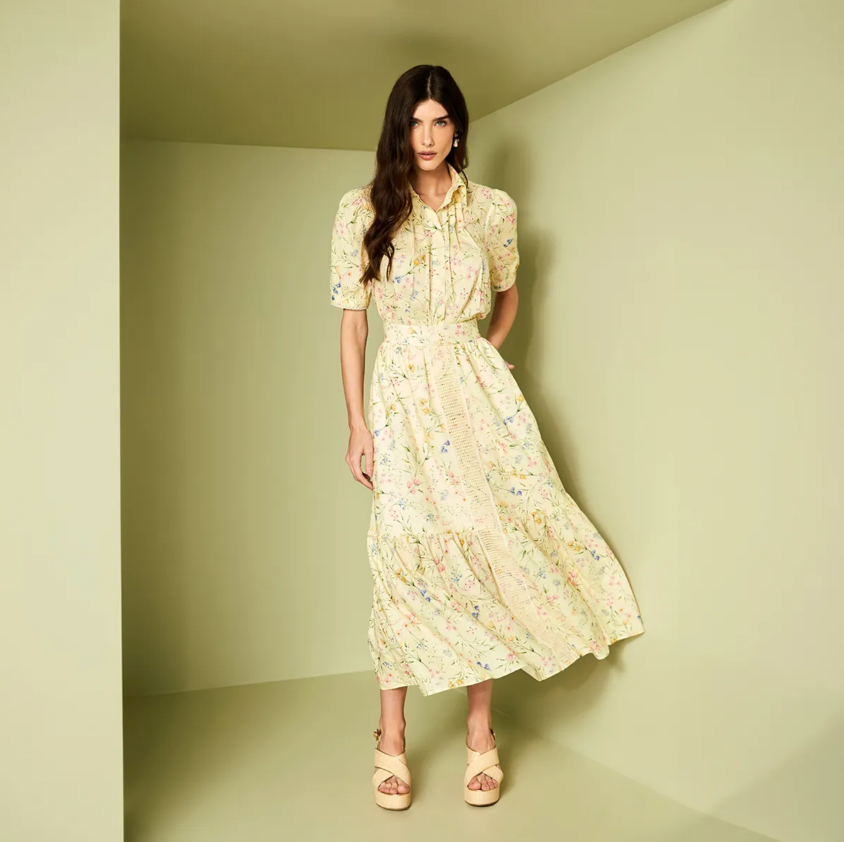 Woman wearing a floral dress against a plain background