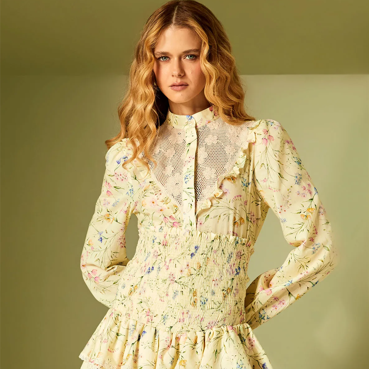 Woman wearing a floral dress against a plain background