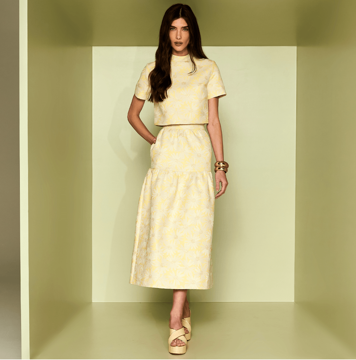 Woman wearing a yellow dress with a subtle pattern against a matching background